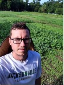 John Allar standing with plots of cover crops behind him in 2019