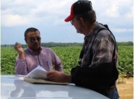 Agronomy researcher, Rishi Prasad (left), discussing results with a farmer engaged in a research field