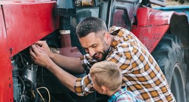 Father and son repair tractor