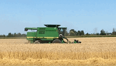 John Deere equipment harvesting grain...