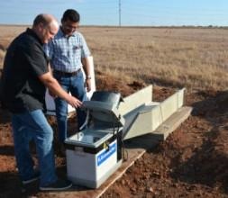Texas A&M AgriLife researchers Paul DeLaune and Srini Ale look at an edge-of-field automatic water sampler near Vernon that will evaluate the effects of soil health promoting practices. 