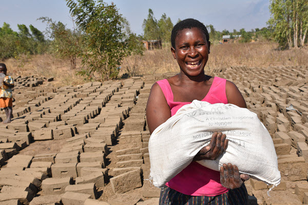 Katherine Chiphwanya holds a bag of maize flour she received in the aftermath of Cyclone Idai through Foodgrains Bank member Presbyterian World Service & Development, with funding from the Humanitarian Coalition. 